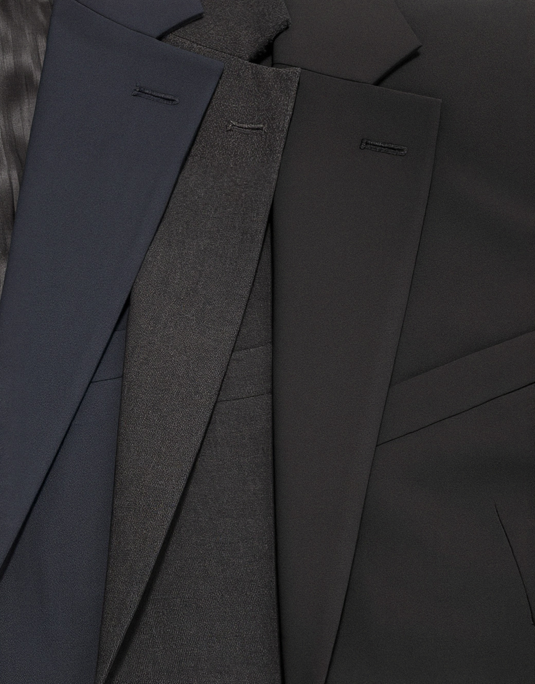Drei rollierte Revers in Marine, Anthrazit und Schwarz — die Verarbeitung der Everyone-Kollektion im Detail